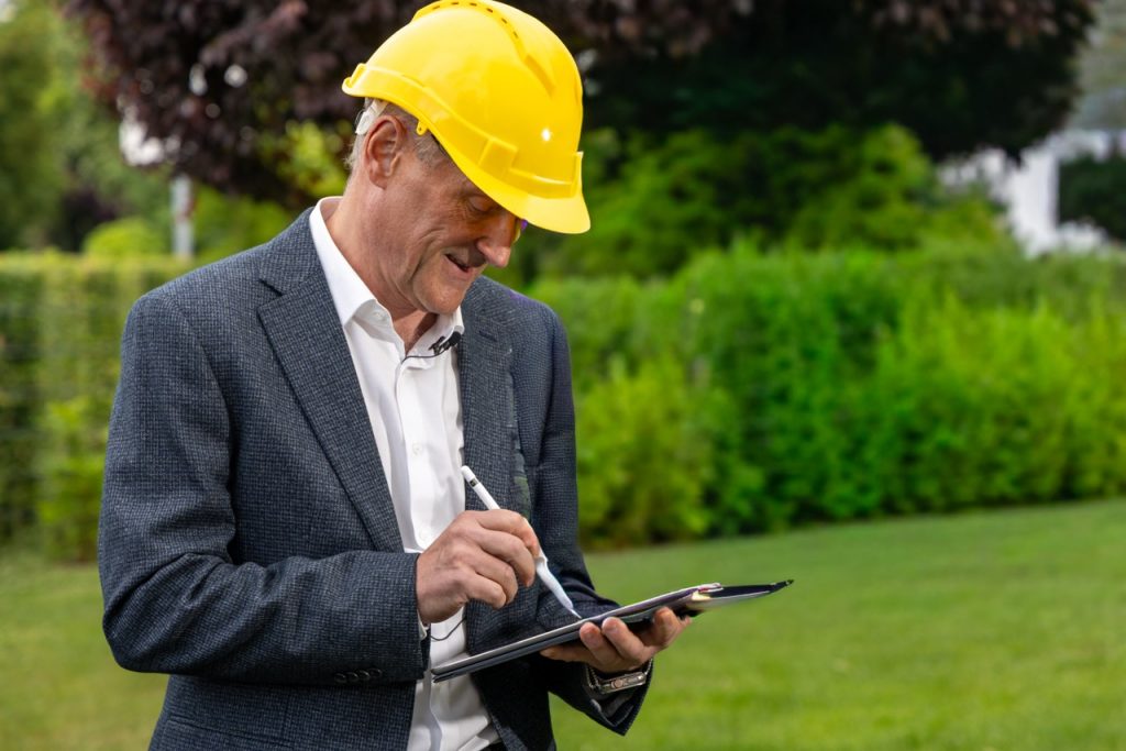 Sachverständiger Peter Reinwald bei der Dokumentation eines Ortstermins auf der Baustelle